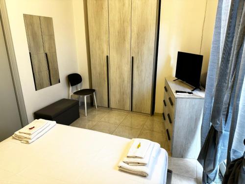 a room with a bed and a desk with a television at Residenza Dartuffo - Apartment - City Centre in Scilla