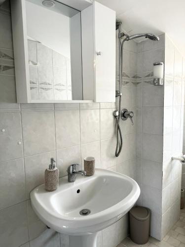 a white bathroom with a sink and a mirror at Residenza Dartuffo - Apartment - City Centre in Scilla