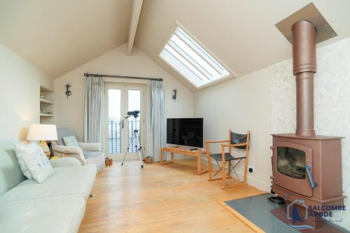una sala de estar con estufa de leña. en Hidden Treasure - Estuary View - Stylish - Garden, en Salcombe