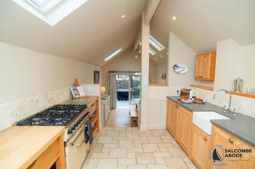 Una cocina con gabinetes de madera y un horno de estufa. en Hidden Treasure - Estuary View - Stylish - Garden, en Salcombe