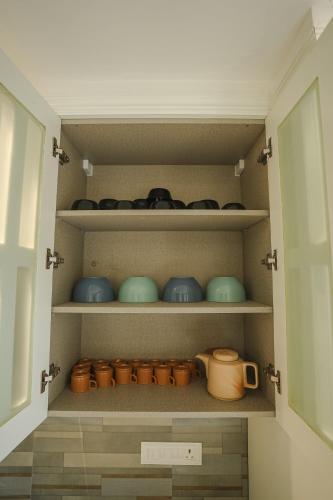 a cupboard filled with lots of pots and pans at VILLA M- SAVANNAH 7- 5BHK Brand New Villa in Calangute with Private Pool, Near Beach, free Breakfast, north goa in Goa