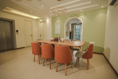 a dining room with a wooden table and chairs at VILLA M- SAVANNAH 7- 5BHK Brand New Villa in Calangute with Private Pool, Near Beach, free Breakfast, north goa in Goa
