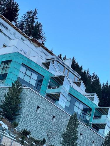 un grand bâtiment au-dessus d'un mur en pierre dans l'établissement Davos Luxury Apartment - 5 Min walking to Congress Center, à Davos
