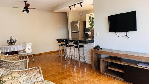 ein Wohnzimmer mit Bar und Flachbildfernseher in der Unterkunft House Relax Parque das Águas Quentes - Apê 2 Quartos in Caldas Novas