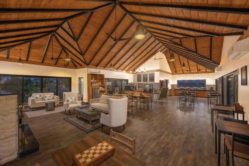 a large living room with wooden ceilings and furniture at Echor Hill Farm Cottages Palampur in Pālampur