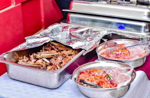 a buffet with three trays of food on a table at Ndanga Hotel in Ruiru