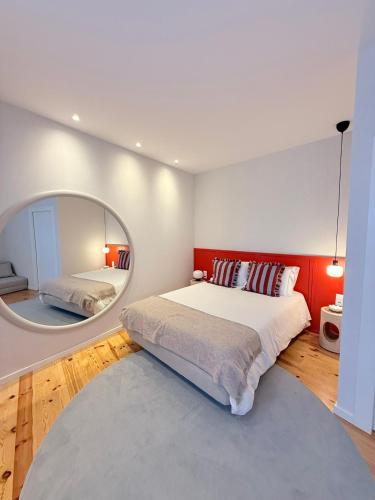a bedroom with a large bed and a mirror at O Laranjal in Guimarães
