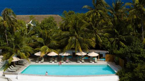 an aerial view of a resort swimming pool with palm trees at OBLU NATURE Helengeli-All-Inclusive with free Transfers in North Male Atoll