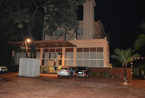 a building with cars parked in front of it at night at TGN SUITES - HOTEL in Raipur