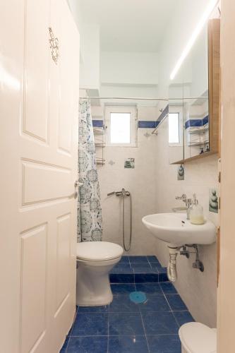 a bathroom with a toilet and a sink at George Central Apartment in Pýrgos