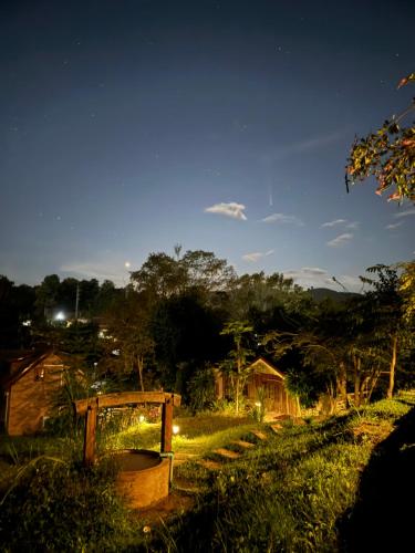 a night view of a field with a house at Ban Kaew Mo Ra Glamping & Restaurant in Pang Mapha