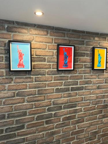 un mur en briques avec quatre images encadrées dans l'établissement loft riviera, à Nice