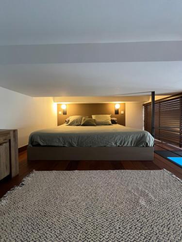 - une chambre avec un lit, deux lampes et un tapis dans l'établissement loft riviera, à Nice