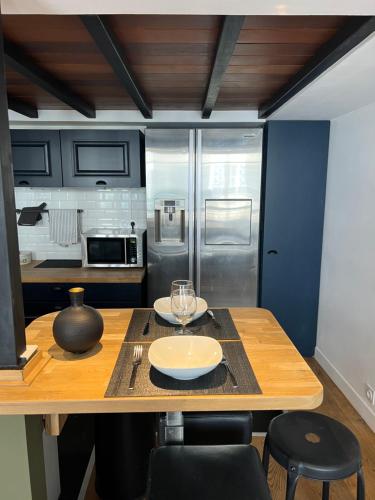 - une cuisine avec une table en bois et 2 assiettes dans l'établissement loft riviera, à Nice