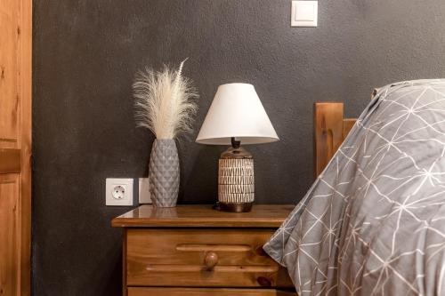 a lamp on a dresser next to a bed at George Central Apartment in Pýrgos
