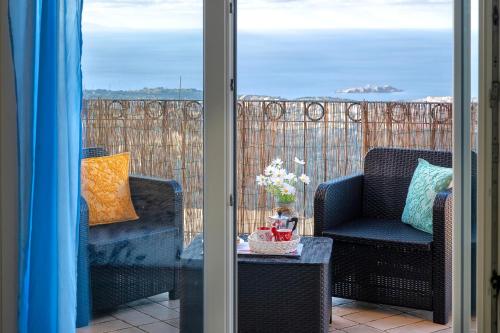 a balcony with two chairs and a table and a window at Rifugio Costiero in Cascabraga