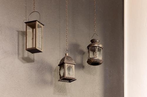 three lanterns hanging on a wall next toermottermott at George Central Apartment in Pýrgos