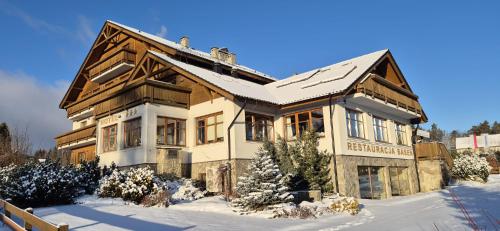 a large house with snow on the ground at Hotel Alpejski in Polanica-Zdrój