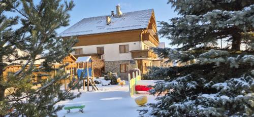 a house with snow on the ground in front of it at Hotel Alpejski in Polanica-Zdrój