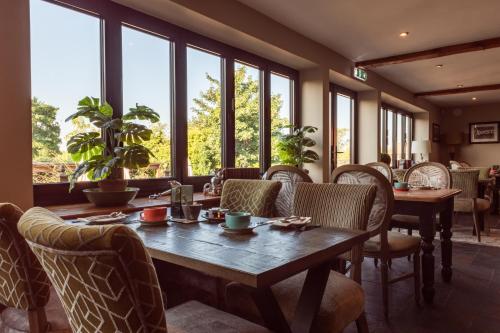 a dining room with a table and chairs and windows at The King William IV - The Coaching Inn Group in Sedgeford