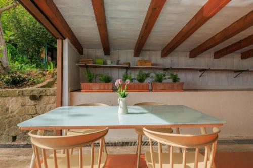 a table and chairs on a patio with plants at Elegante Appartamento con Vista - Colli Euganei in Teolo