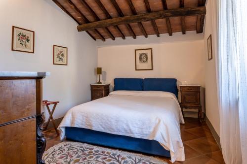 LurianoにあるNociarella - Podere Casolare nel cuore della Toscanaの白いベッドと木製の天井が備わるベッドルーム1室が備わります。