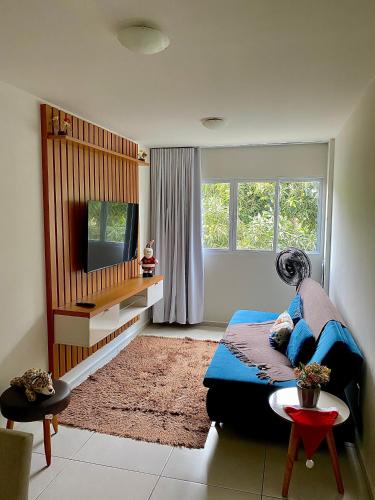 a bedroom with a bed and a tv and a table at Apartamento Lótus Ar Cond Pertinho FIG e Centro in Garanhuns