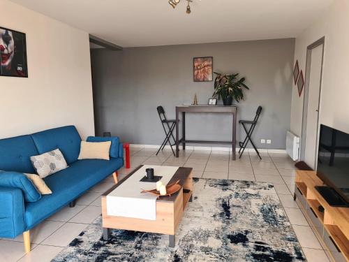 un salon avec un canapé bleu et une table dans l'établissement Gîte de 70m² avec vue sur le massif du Pilat, à Clonas-sur-Varèze