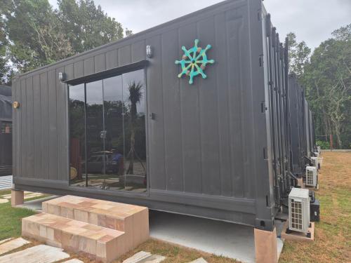 a black shipping container with a door and a window at Aldeia Mar in Bertioga