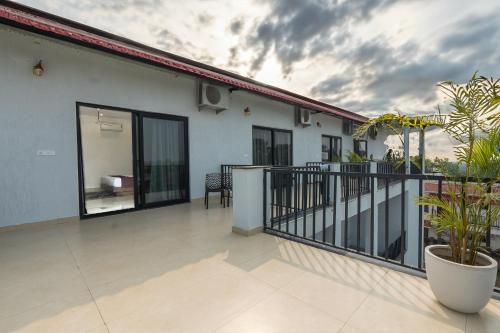a balcony of a house with glass doors at Corbett Tusker Meadows by White Flower in Rāmnagar