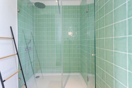 La salle de bains est pourvue d'une douche avec du carrelage vert. dans l'établissement Baixa Luxury Penthouse - Stunning Downtown Views, à Lisbonne