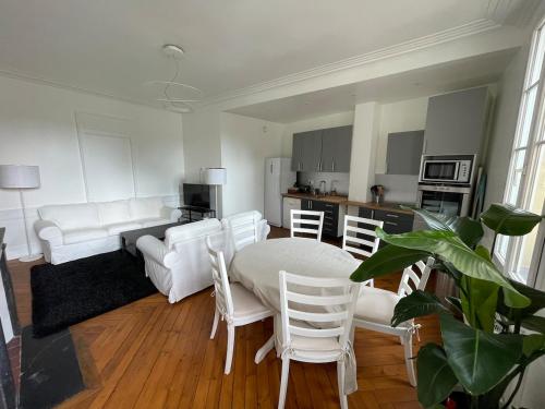 Il comprend un salon doté d'un mobilier blanc, d'une table et de chaises. dans l'établissement Appartement Hypercentre vue Cathédrale, à Rouen
