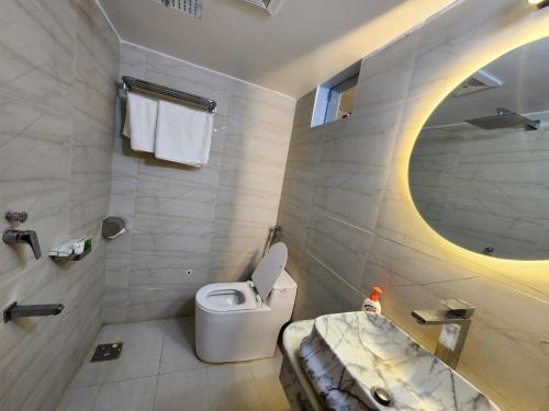 un bagno con un water, un lavandino e uno specchio di Beach Anaya Food Junction & Resort a Cox's Bazar