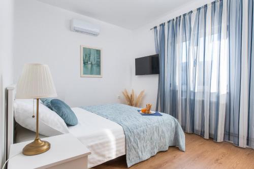 a bedroom with a bed and a table with a lamp at Villa Magnolia with heated Pool and Jacuzzi, near sea in Tugare