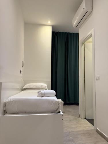 a bedroom with two beds and a green curtain at Relais Merulana Guest House in Rome