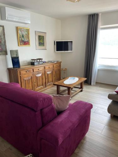 a living room with a purple couch and a table at Appartamenti Ramarro in Ronco s/Ascona - Porto Ronco