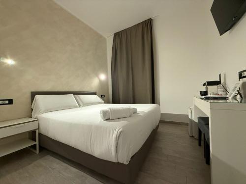 a bedroom with a large white bed and a desk at Relais Merulana Guest House in Rome