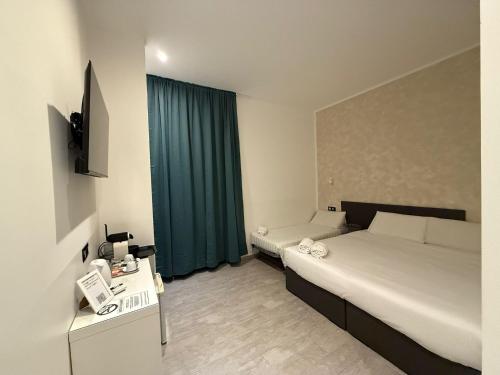 a bedroom with a bed and a desk and a window at Relais Merulana Guest House in Rome