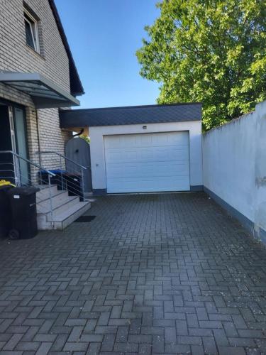 a garage with a white door on a house at Souterrain Whirlpool-Apartment nahe Phantasialand in Weilerswist