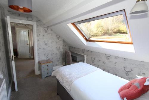 a attic bedroom with a bed and a window at Fern Howe Guest House in Keswick