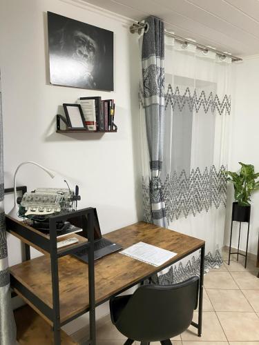 an office with a wooden desk and a chair at Souterrain Whirlpool-Apartment nahe Phantasialand in Weilerswist