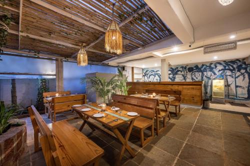 Echor Samara Morjim Goa Sea view Restro في مورجيم: مطعم بطاولات خشبية وكراسي خشبية