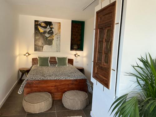 a bedroom with a bed and two stools in it at Krisant Gold Rural Luxury Privat Pool in Santa Cruz de Tenerife