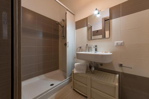 a bathroom with a sink and a shower and a tub at BluSide Home & Suite in San Vito lo Capo