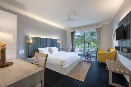 una camera d'albergo con un letto e un soggiorno di Echor Samara Morjim Goa Sea view Restro a Morjim
