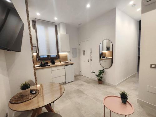 a kitchen with a table and two chairs and a mirror at La estación in Málaga