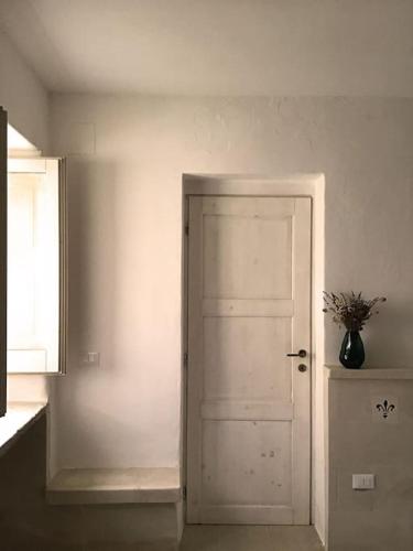 a room with a white door and a vase with a plant at Casa Carulì in Cerfignano