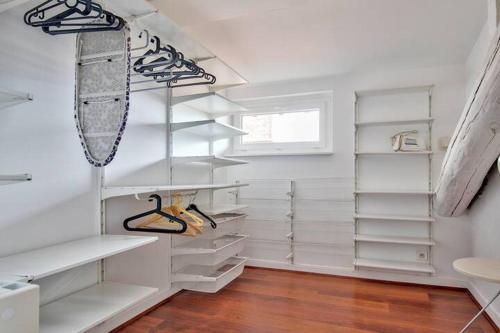 - un dressing blanc avec des étagères blanches dans l'établissement Charmant T2 climatisé à proximité de la gare Saint-Roch, à Montpellier