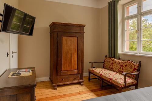 a living room with a chair and a cabinet at Museumsbahnhof Ahütte in Üxheim