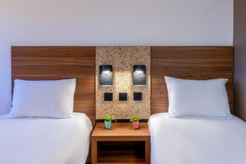 two beds in a hotel room with white pillows at greet Hotel Chatellerault in Châtellerault